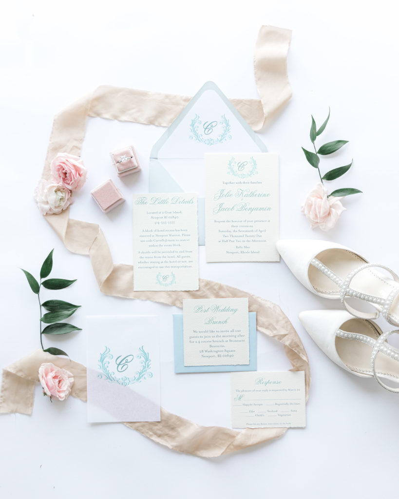 Pastel blue and cream wedding invitations with envelope liner, ribbon, and vellum embellishments.