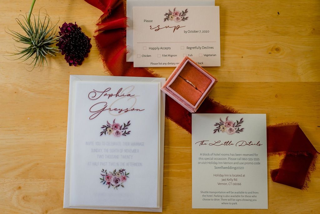 Vellum sheet embellishments on pink floral invitation set.