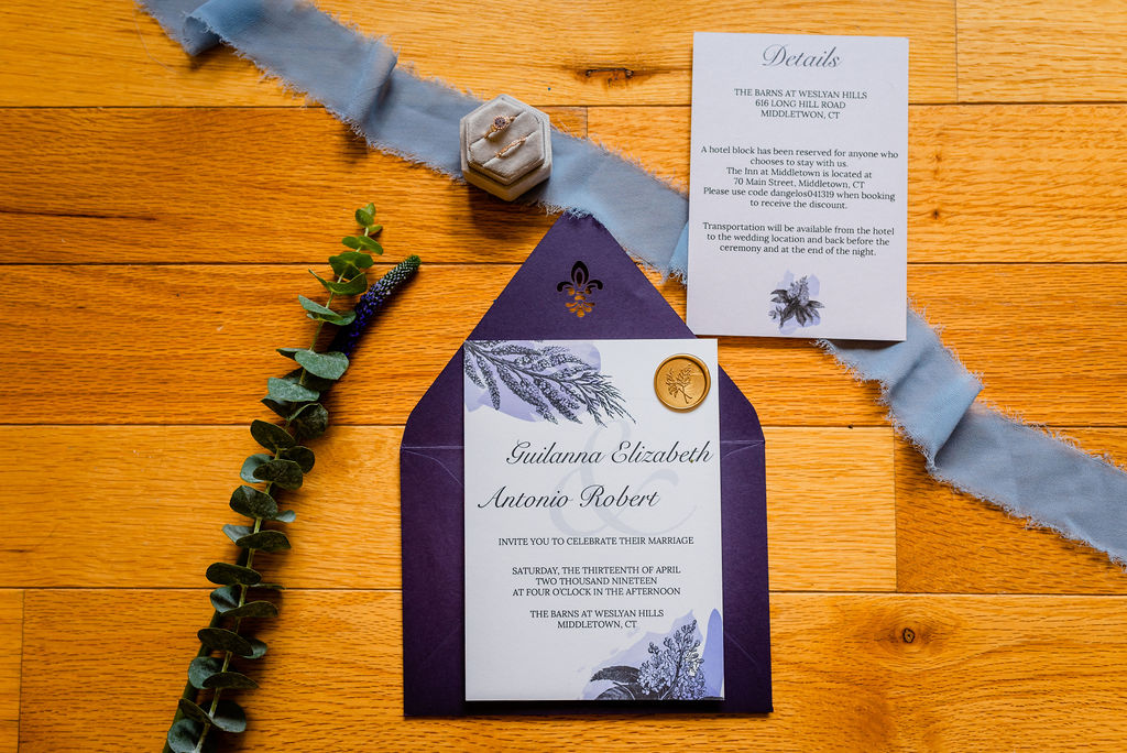 Dark purple wedding invitation with gold wax seal embellishments.