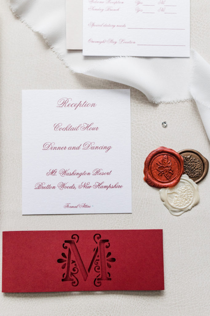 Multiple invitation embellishments, wax seals, and diecut belly bands.