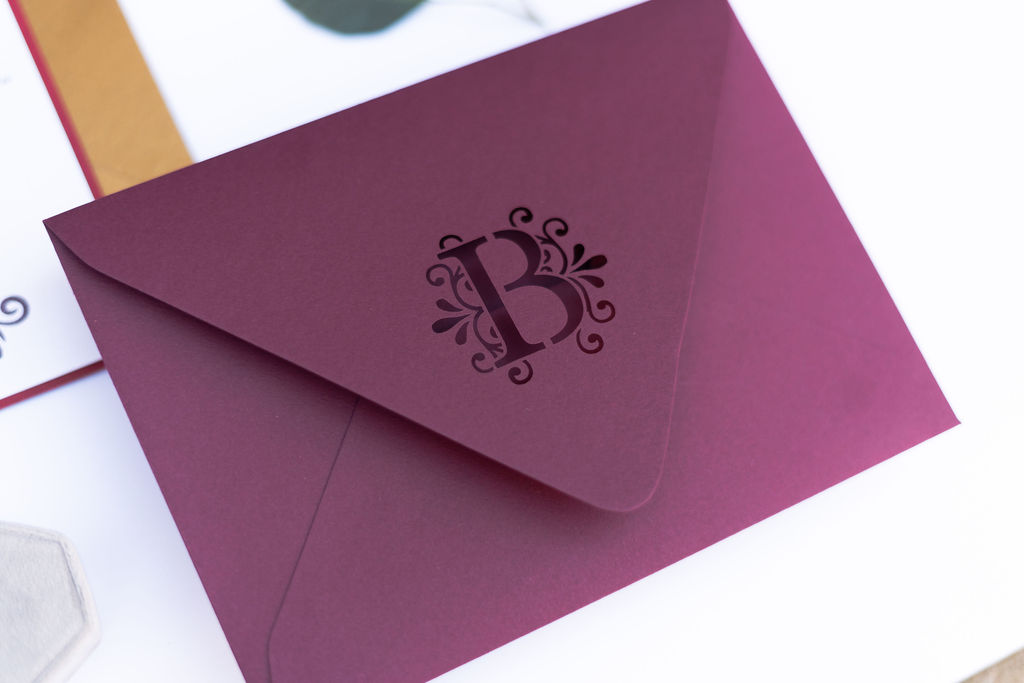 Wine red winter wedding envelope with monogram diecut and gold accent