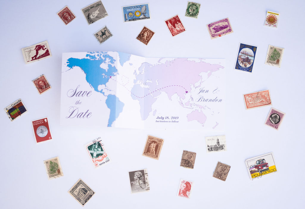 Save-the-date stationery card with images of continents connecting surrounded by various stamps.