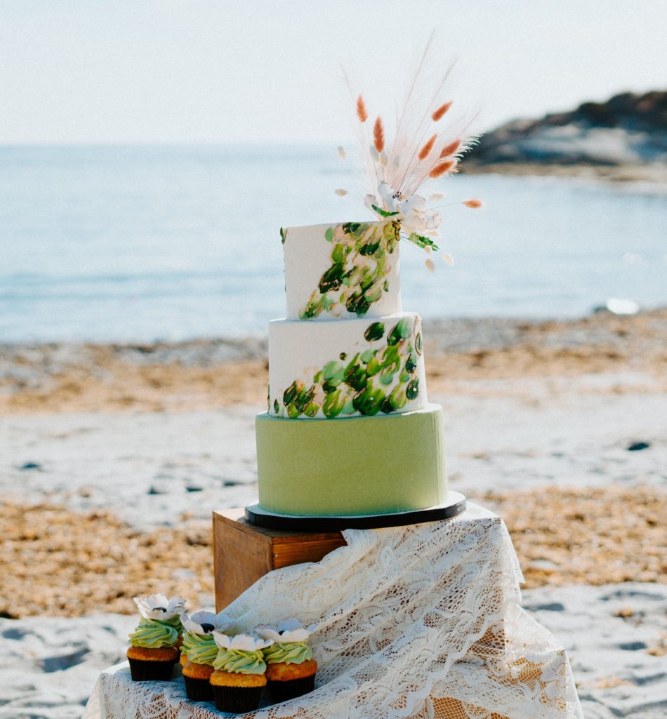 Green and white wedding cake and matching cupcakes for beach elopement.