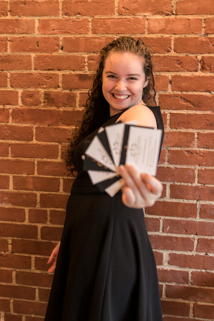 CCB designer, Lauren, holding business cards. 
