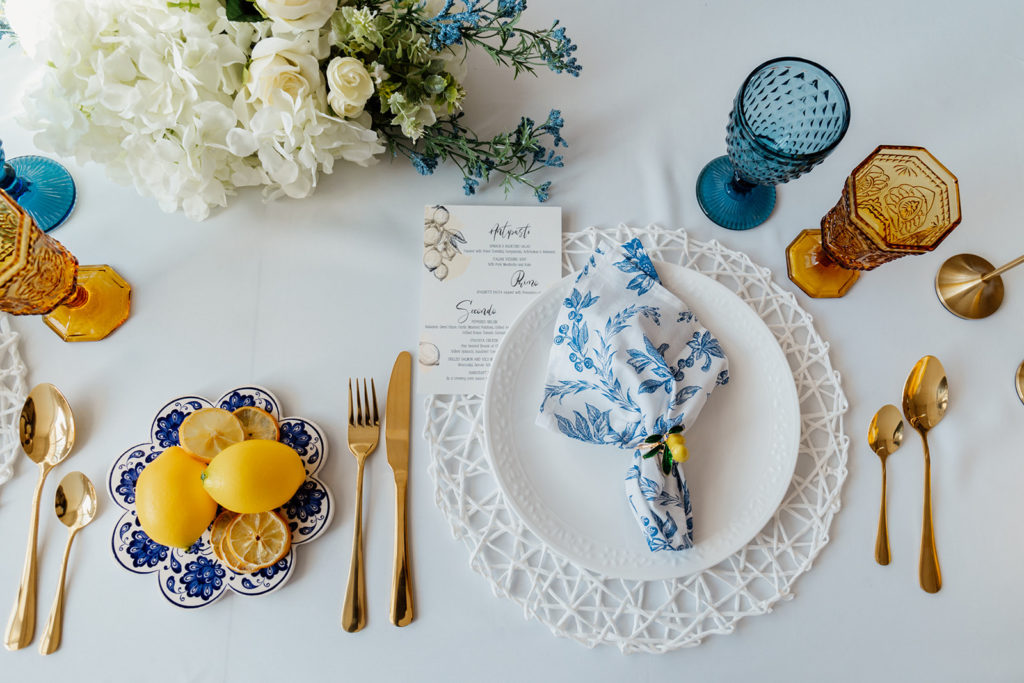 Wedding menu and table setup. Features blue and yellow italian-inspired decor. 