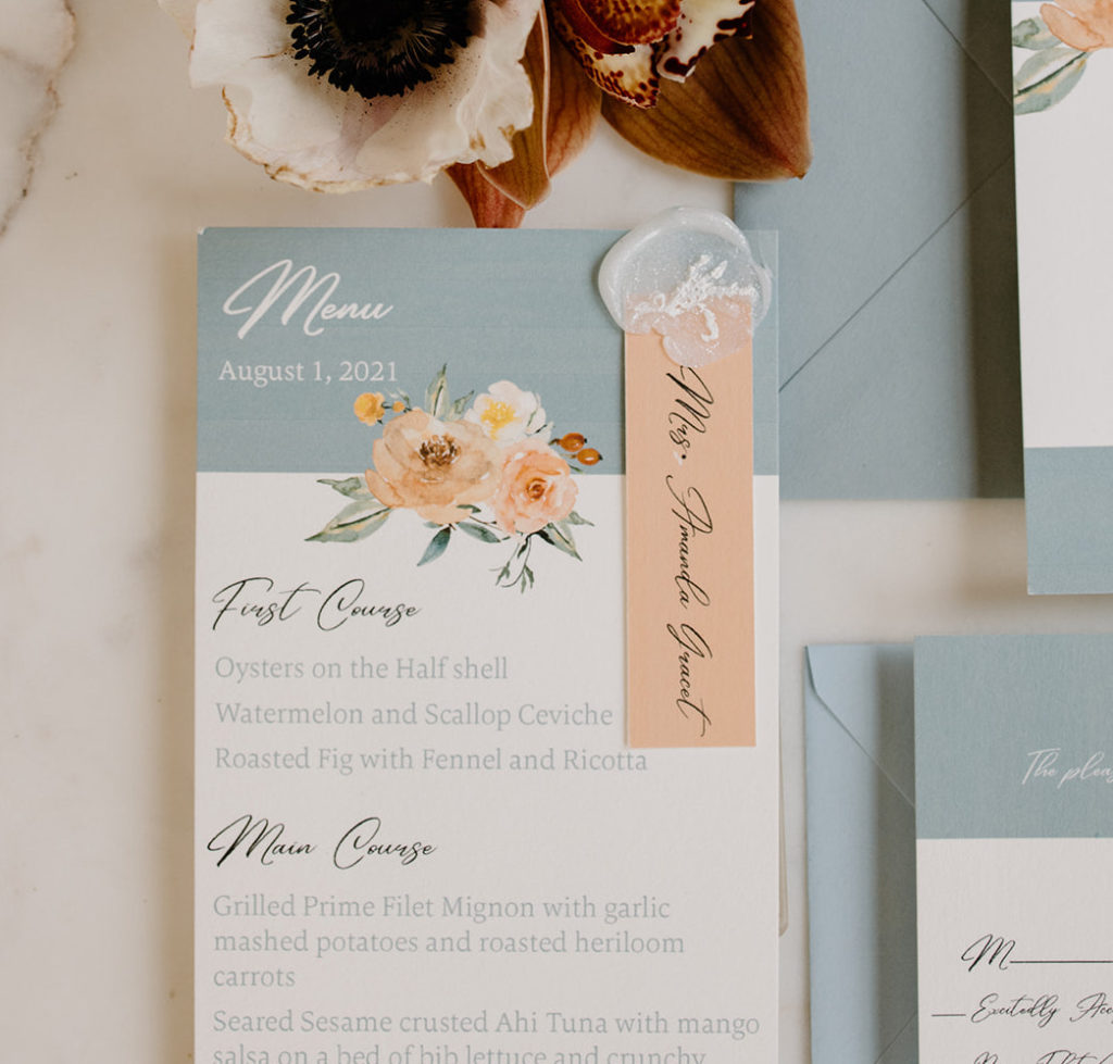 Personalized wedding menu with guests name attached with a wax seal.